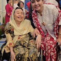 Mayangsari tampil anggun kenakan atasan putih berbahan brokat dengan detail bordir bunga yang indah. Atasan tersebut dipadukan dengan bawahan kain merah bermotif, memberi kesan mewah dan tradisional. Foto: Instagram/@mayangsari_official