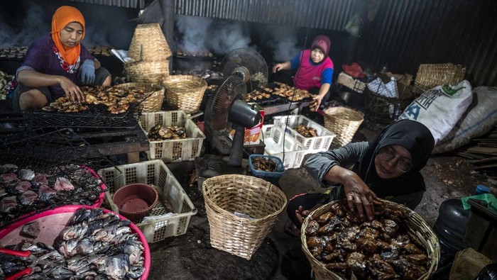 Dua pekerja melakukan proses pengolahan ikan asap di sentra pengasapan ikan Bandarharjo, Semarang, Jawa Tengah, Selasa (19/8/2025). Pemerintah menargetkan penyaluran usaha rakyat (KUR) dalam Rancangan Anggaran Pendapatan dan Belanja Negara (RAPBN) 2026 sebesar Rp320 triliun dengan subsidi bunga Rp36,5 triliun yang bertujuan untuk mempermudah akses pembiayaan UMKM. ANTARA FOTO/Aprillio Akbar/nym.
