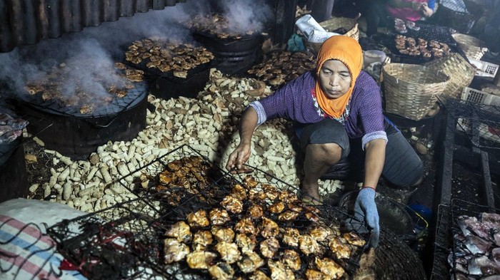 Dua pekerja melakukan proses pengolahan ikan asap di sentra pengasapan ikan Bandarharjo, Semarang, Jawa Tengah, Selasa (19/8/2025). Pemerintah menargetkan penyaluran usaha rakyat (KUR) dalam Rancangan Anggaran Pendapatan dan Belanja Negara (RAPBN) 2026 sebesar Rp320 triliun dengan subsidi bunga Rp36,5 triliun yang bertujuan untuk mempermudah akses pembiayaan UMKM. ANTARA FOTO/Aprillio Akbar/nym.