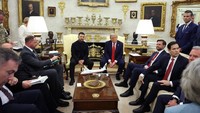 Saat era Trump, dinding Oval Office terlihat semakin meriah. Ada sejumlah potret ditambahkan dalam bingkai lebih dekoratif. Bagian perapian pun ditambahkan ornamen emas serta dipajang deretan cawn emas. Kemudian, karpet lantai diganti dengan warna lebih kalem. Foto: Getty Images via AFP/ANNA MONEYMAKER