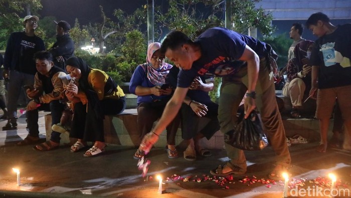 Warga menyalakan lilin dan tabur bunga di depan kantor Bupati Pati, Rabu (20/8/2025).