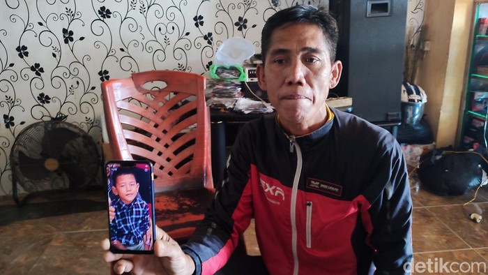 Burhan menunjukkan foto anaknya yang sudah sepekan menghilang.