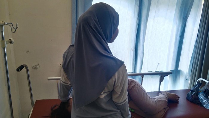 CW, siswi SMK Karya Adi Husada yang diduga keracunan menu MBG, ditemani rekan sekolahnya saat dirawat di Puskesmas Selong, Lombok Timur, Rabu (20/8/2025). (Sanusi Ardi W/detikBali)