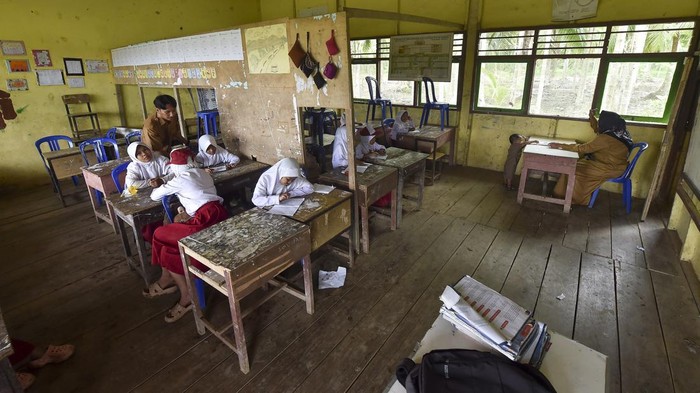 Guru mengajar di satu ruang kelas bersekat di SDN 203 Air Hitam Laut, Tanjung Jabung Timur, Jambi, Selasa (19/8/2025). Sekolah yang berjarak sekitar 160 kilometer atau 3 jam perjalanan menggunakan kapal cepat dari pusat Pemerintahan Kabupaten Tanjung Jabung Timur itu terpaksa menyekat semua ruang kelas untuk kegiatan belajar mengajar sebanyak 83 muridnya karena hanya memiliki 3 ruangan kelas. ANTARA FOTO/Wahdi Septiawan/rwa.