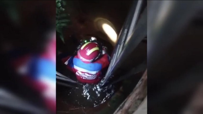 Tim pemadam kebakaran saat mengevakuasi kucing masuk sumur di Palembang.