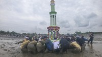 Petugas bersama warga mengarak menara adat ke tepi pantai saat puncak pelaksanaan tradisi Mandi Safar di Air Hitam Laut, Tanjung Jabung Timur, Jambi, Rabu (20/8/2025). ANTARA FOTO/Wahdi Septiawan