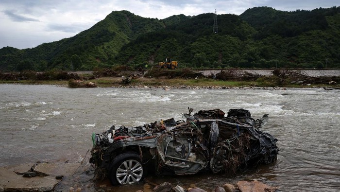 A family portrait lies among damaged household items and debris near a house, following heavy rains in late July that flooded the village, in Huairou district of Beijing, China, August 13, 2025. REUTERS/Tingshu Wang
