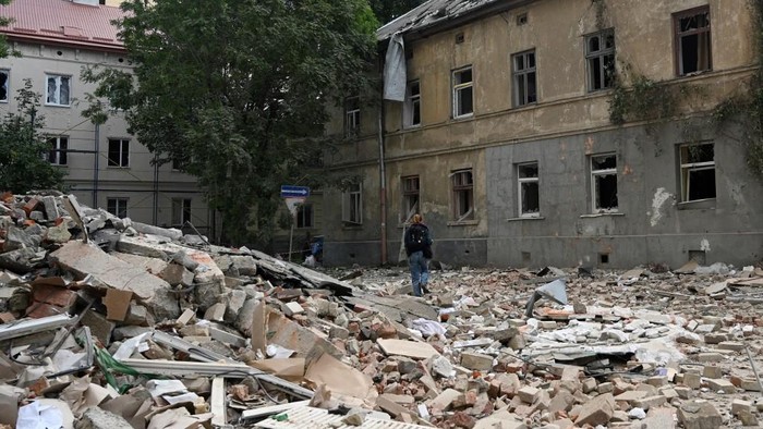 Dampak serangan udara Rusia di kota Lviv, Ukraina bagian barat A person walks past a residential building damaged following Russian air attacks in the western Ukrainian city of Lviv on August 21, 2025, amid the Russian invasion of Ukraine. Russia launched hundreds of drones and missiles at Ukraine overnight, the Ukrainian air force said on August 21, 2025, Moscows largest attack in weeks after US-led efforts to halt the Kremlins invasion. (Photo by YURIY DYACHYSHYN / AFP)