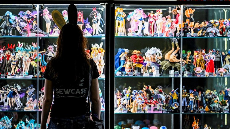 A person looks at merchandise displayed during Gamescom 2025, a computer and video game industry event, in Cologne, Germany August 20, 2025. REUTERS/Jana Rodenbusch REFILE  - QUALITY REPEAT      TPX IMAGES OF THE DAY