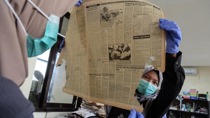 Mahasiswa magang didampingi pegawai bagian Konservasi Preservasi memperbaiki koran terbitan lama koleksi Museum Pers Nasional di Solo, Jawa Tengah, Kamis (21/8/2025). Kegiatan pelestarian koran terbitan lama dari berbagai media dan surat kabar di Indonesia itu sebagai upaya penyelamatan arsip koleksi setempat yang selanjutnya dilakukan proses alih media digital guna mempermudah akses informasi bagi masyarakat. ANTARAFOTO/Maulana Surya/nz. *** Local Caption ***