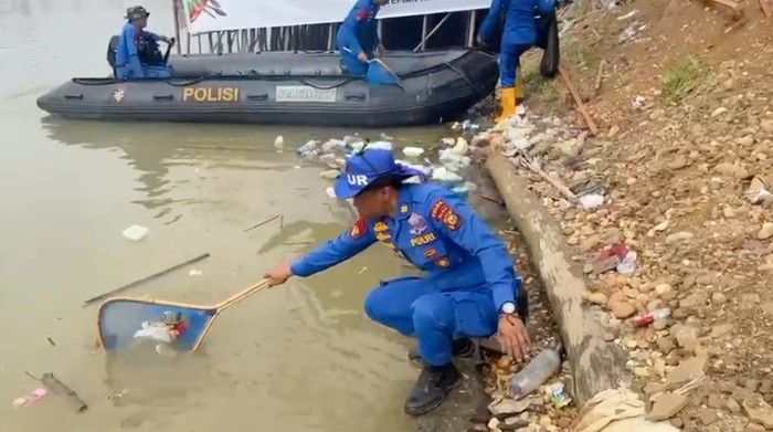 Personel Ditpolairud Polda Riau turun membersihkan sampah di pinggir Sungai Kuantan arena Pacu Jalur, Kamis (21/8/2025).