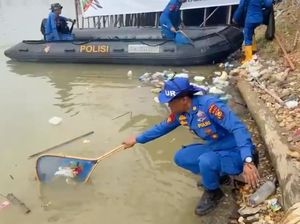 Personel Polda Riau Bersih-bersih Sampah di Tepian Narosa Arena Pacu Jalur