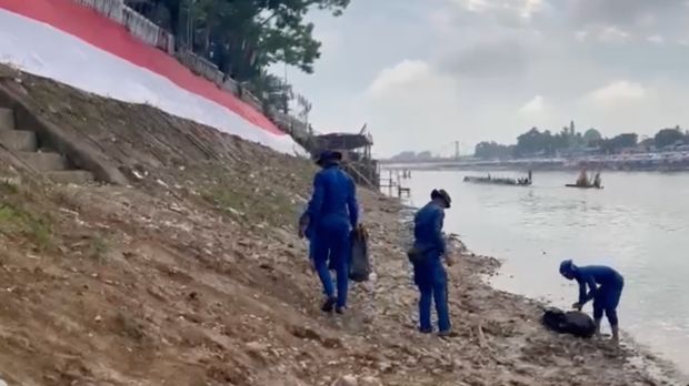 Personel Ditpolairud Polda Riau turun membersihkan sampah di pinggir Sungai Kuantan arena Pacu Jalur, Kamis (21/8/2025).
