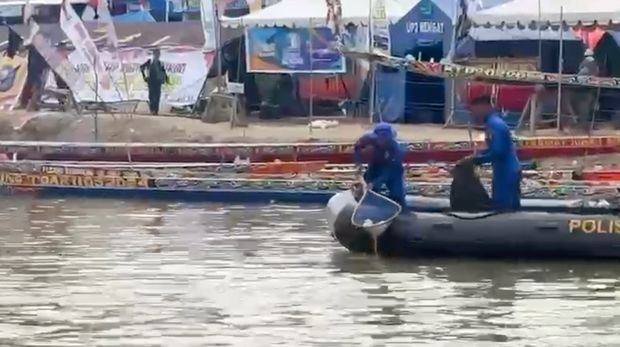 Personel Ditpolairud Polda Riau turun membersihkan sampah di pinggir Sungai Kuantan arena Pacu Jalur, Kamis (21/8/2025).