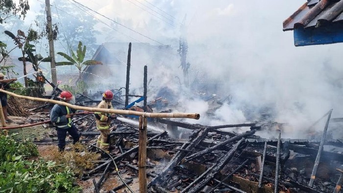 Petugas Damkar Pos WMK Kawali memadamkan api yang membakar rumah pasangan lansia.
