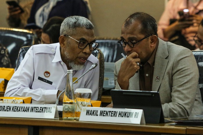 Wakil Menteri Hukum Edward Omar Sharif Hiariej (kanan) berbincang dengan Dirjen Kekayaan Intelektual Razilu (kiri) mengikuti Rapat Dengar Pendapat Umum (RDPU) dengan Wakil Ketua DPR Sufmi Dasco Ahmad dan Komisi XIII DPR di Kompleks Parlemen, Senayan, Jakarta, Kamis (21/8/2025). Rapat tersebut membahas manajemen Royalti dan permasalahan dalam perlindungan karya cipta dan hak cipta. ANTARA FOTO/Asprilla Dwi Adha/nz