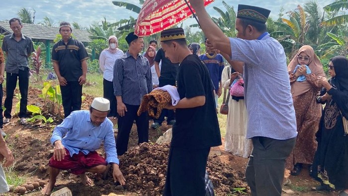 Sandi membawa jenazah putrinya untuk dimakamkan