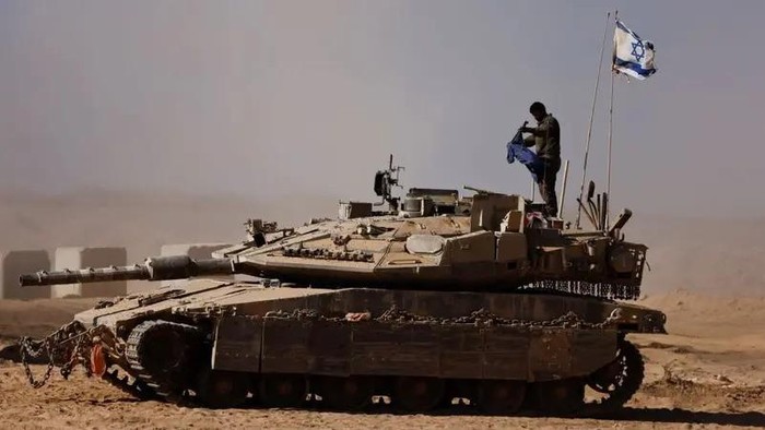 An Israeli soldier stands on a tank on the Israeli side of the border with Gaza on August 20, 2025. (Reuters)