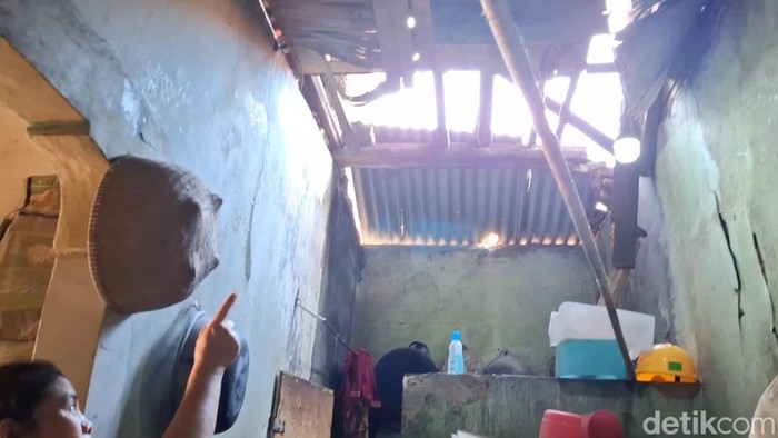 Warga Purwakarta menunjukkan kerusakan rumahnya akibat gempa Bekasi.