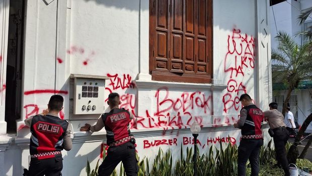 Anggota Polresta Bogor membersihkan vandalisme di Gedung Balai Kota Bogor.