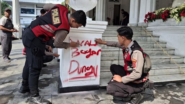 Anggota Polresta Bogor membersihkan vandalisme di Gedung Balai Kota Bogor.