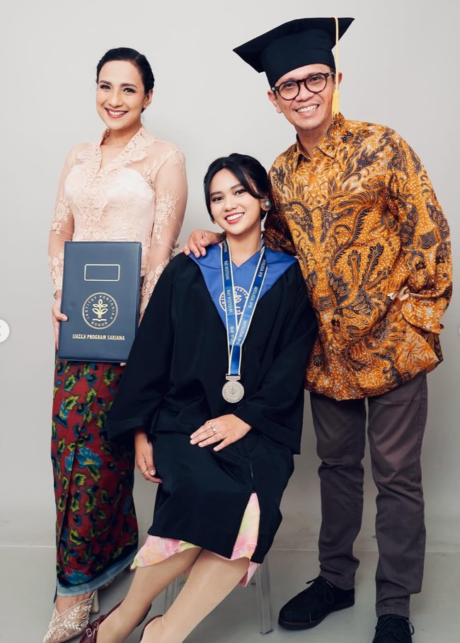 Shahnaz Haque dan Gilang Ramadhan turut hadir menemani Charlotte di acara wisudanya. Shahnaz memilih kebaya warna soft pastel dipadukan kain lilit warna merah tua dengan corak biru dan hijau. Sementara Gilang mengenakan kemeja batik lengan panjang berwarna coklat. Foto: Instagram/@shahnaz.haque/@charlotteramadhan