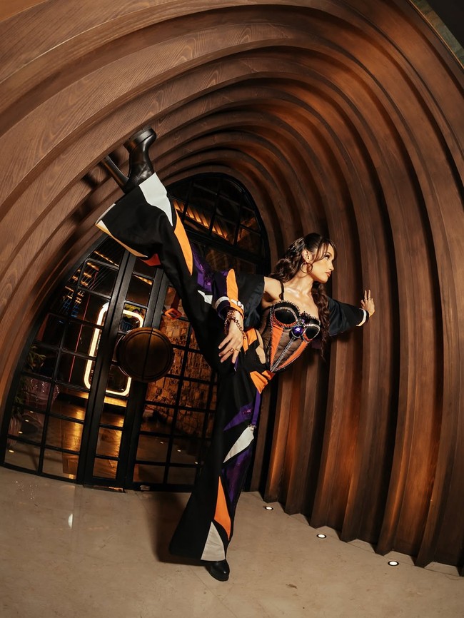 Celana wide-leg bernuansa sporty dengan kombinasi warna kontras—ungu metalik, putih, dan hitam— menambah vibe dinamis dan modern. Kacamata hitam oversized menegaskan kesan bold, sementara gelang simpel memberi detail feminin. Foto: Instagram/@claurakiehl