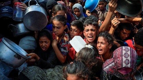 FILE PHOTO: Palestinians wait to receive food from a charity kitchen, in Khan Younis, southern Gaza Strip, August 21, 2025. REUTERS/Hatem Khaled/File Photo