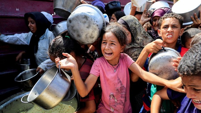 FILE PHOTO: Palestinians wait to receive food from a charity kitchen, in Khan Younis, southern Gaza Strip, August 21, 2025. REUTERS/Hatem Khaled/File Photo