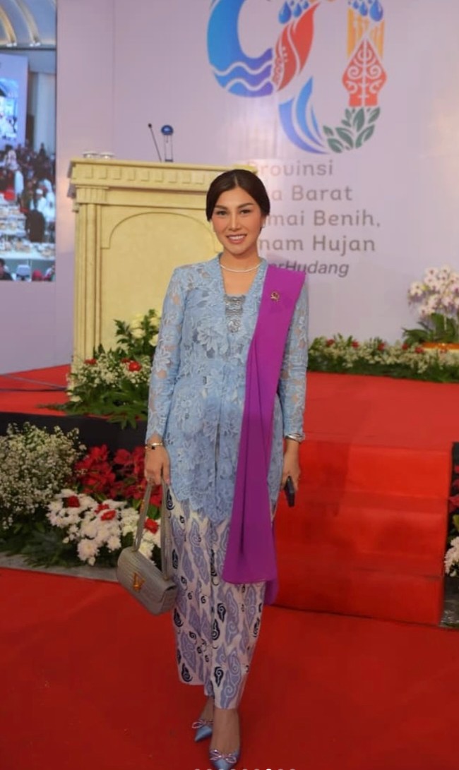 Nisya Mengenakan kebaya brokat berwarna biru muda dengan kain batik bermotif warna pink nude, ungu, dan hitam. Di bahunya tersampir selempang ungu yang memberi aksen tegas pada penampilannya. Foto: Instagram/@syahnazs/@nissyaa