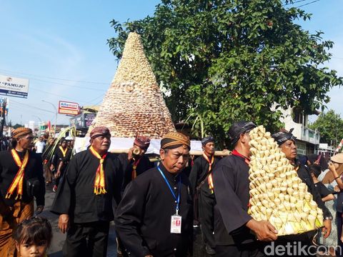 Momen warga saat berebut apem kukus keong emas di Pengging, Banyudono, Boyolali, Jumat (22/8/2025).