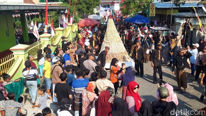 Momen warga saat berebut apem kukus keong emas di Pengging, Banyudono, Boyolali, Jumat (22/8/2025).
