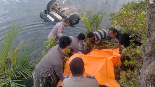 petugas kepolisian saat mengevakuasi jasad korban.