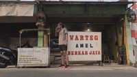 Pakai kaos dan celana pendek, ini momen Lembu pose di depan Warteg dan kedai bubur sehat buat bayi. Ia mampir ke sini setelah olahraga lari 5 km. Foto: Instagram lembuwiworojati
