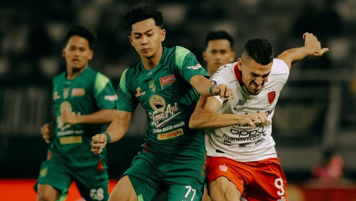 Pemain Bali United Boris Kopitovic (kanan) dikawal winger Persebaya Malik Rizaldi dalam pekan ketiga Super League di Stadion Gelora Bung Tomo, Surabaya,Sabtu (23/8/2025). (Foto: Dok. Bali United)