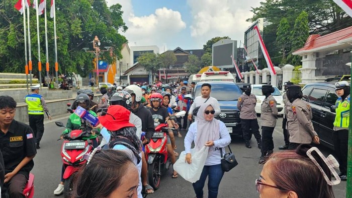 Polisi ikut mengawal dan mengamankan aksi pembagian nasi bungkus di Pati. Foto diunggah Sabtu (23/8/2025).
