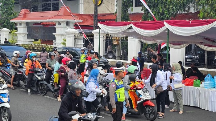 Polisi ikut mengawal dan mengamankan aksi pembagian nasi bungkus di Pati. Foto diunggah Sabtu (23/8/2025).