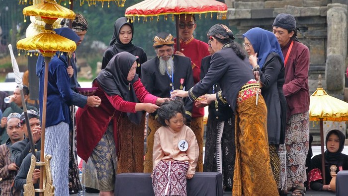 Wisatawan menyaksikan prosesi ritual pemotongan rambut anak bajang atau anak berambut gimbal di komplek Candi Arjuna Dataran Tinggi Dieng, Desa Dieng Kulon, Batur, Banjarnegara, Jawa Tengah, Minggu (24/8/2025). Sebanyak delapan anak bajang menjalani ritual potong rambut gimbal dalam rangkaian Dieng Culture Festival (DCF) 2025 yang mengusung tema “Back To The Culture”. ANTARA FOTO/Anis Efizudin