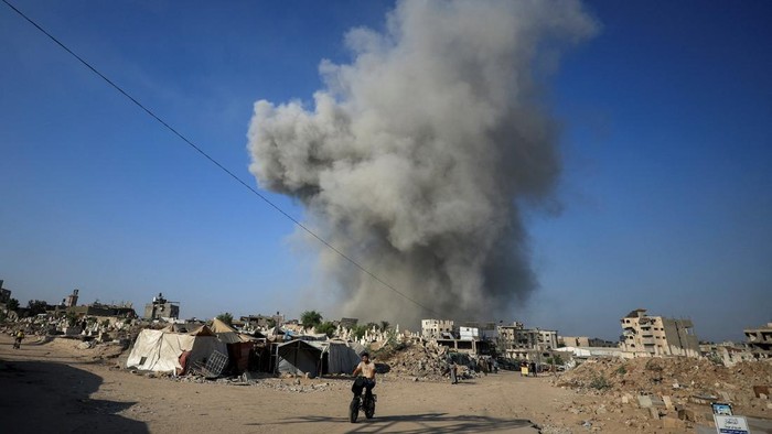 Kota Gaza dilanda kepulan asap menyusul serangan udara yang dilancarkan Israel, Minggu (24/8/2025). Warga Palestina terlihat berjalan di tengah debu dan asap tebal yang menutupi jalan-jalan utama kota, menciptakan pemandangan dramatis dan penuh kecemasan. REUTERS/Dawoud Abu Alkas