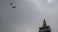 Sebanyak 10 penerjun payung Kopassus melompat dari pesawat dengan membawa atribut Merah Putih yang berkibar megah di udara. Kehadiran mereka langsung menyedot perhatian ribuan peserta dan penonton yang memadati kawasan Monas. ANTARA FOTO/Bayu Pratama S
