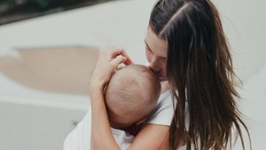 Di foto kedua, pendiri Rhode itu menggendong putranya sambil mengecup kening. Ibu dan anak itu mengenakan kaus putih dengan warna senada buat pemotretan.   Foto: Dok.Instagram Hailey