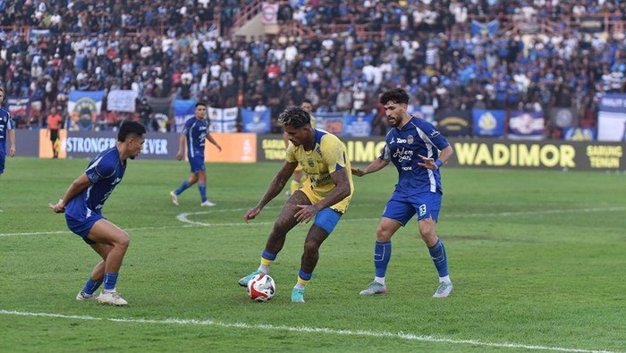 Ramon Tanque dikawal dua pemain lawan dalam laga PSIM vs Persib di Stadion Sultan Agung, Bantul, Minggu (24/8/2025).