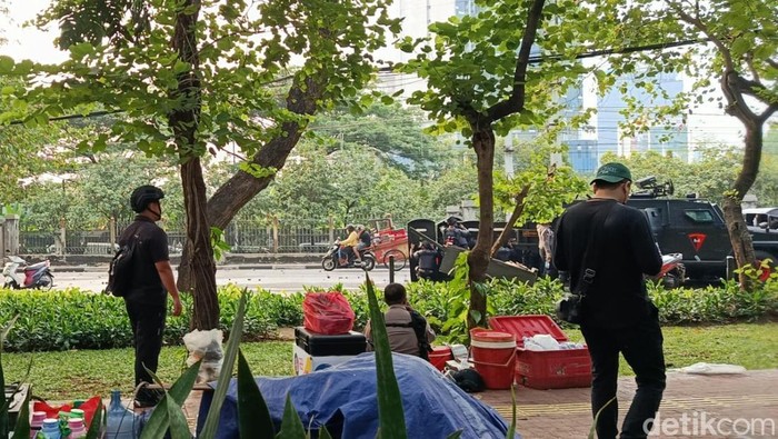 Ada momen menarik saat aksi unjuk rasa 25 Agustus di depan Gedung DPR/MPR RI hari ini. Ada pedagang dengan santai membelah lautan massa yang sedang ricuh. (Wildan N/detikcom)