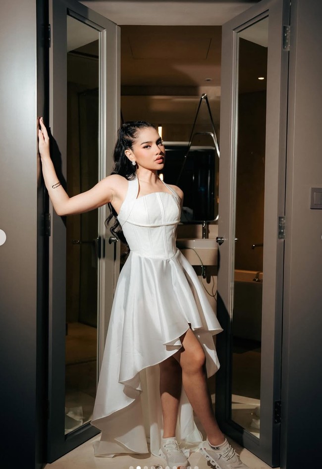 Davina Karamoy merayakan pertambahan usianya dengan gaya unik, memadukan tampilan feminin dan sporty yang memukau. Ia memadukan dress halter neck putih dengan sepatu olahraga senada. Foto: Instagram/@davinaakaramoy