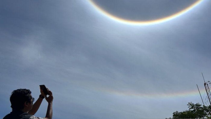 Seorang warga mendokumentasikan fenomena halo yang sedang menghiasi langit Kota Batam, Kepulauan Riau, Senin (25/8/2025). (ANTARA/Istimewa)