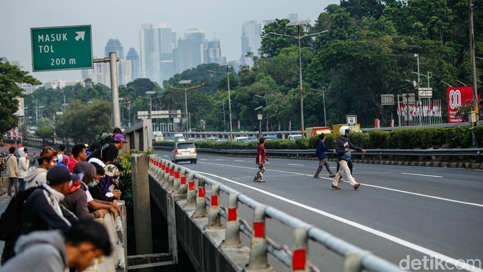 Massa Demo DPR Tutup Tol - Rusak Mobil Plat Merah Sejumlah massa aksi menutup ruas Tol Dalam Kota arah Semanggi di Flyover Pejompongan, Jakarta, Senin (25/8/2025).