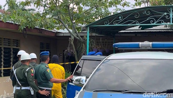 Pelaku saat diboyong menuju ke dalam rumahnya saat rekonstruksi. (Finta Rahyuni/detikSumut)