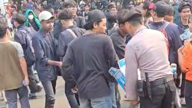 Polisi membagikan air mineral kepada pendemo di Senayan, Jakarta Pusat, Senin (25/8/2025)