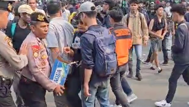 Polisi membagikan air mineral kepada pendemo di Senayan, Jakarta Pusat, Senin (25/8/2025)