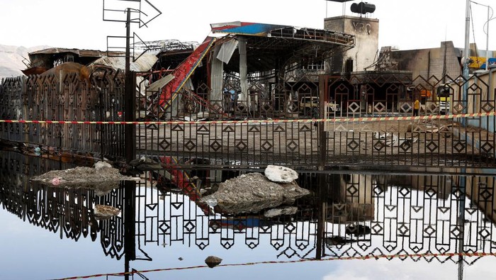 People stand outside a fuel station one day after it was hit by Israeli airstrikes in Sanaa, Yemen August 25, 2025. REUTERS/Stringer